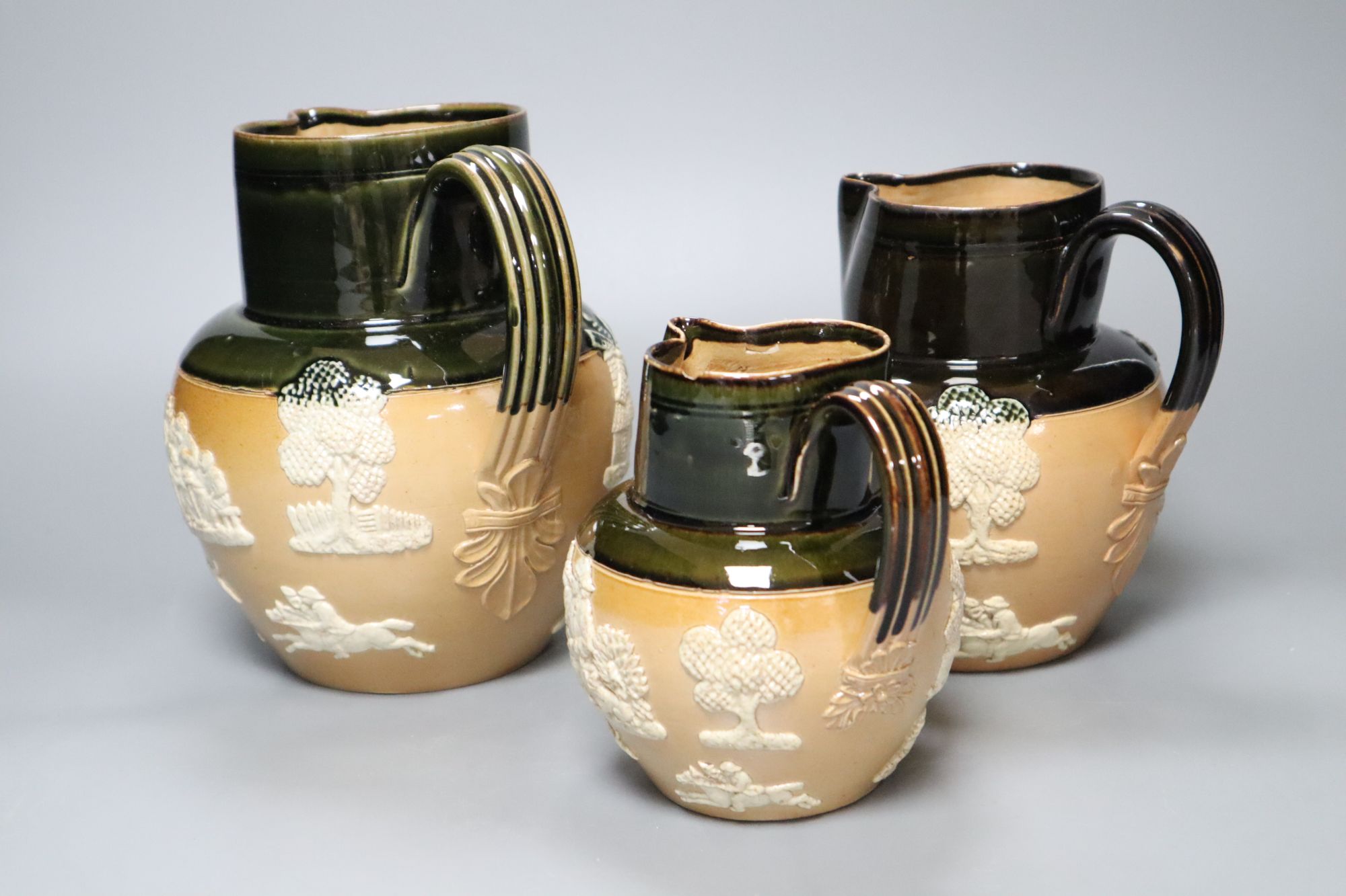 A graduated set of three Victorian Royal Doulton earthenware harvest jugs, tallest 19cm